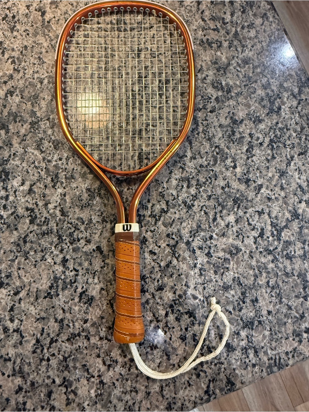 Wilson Orange Tennis Racket with Brown Grip and Wrist Cord